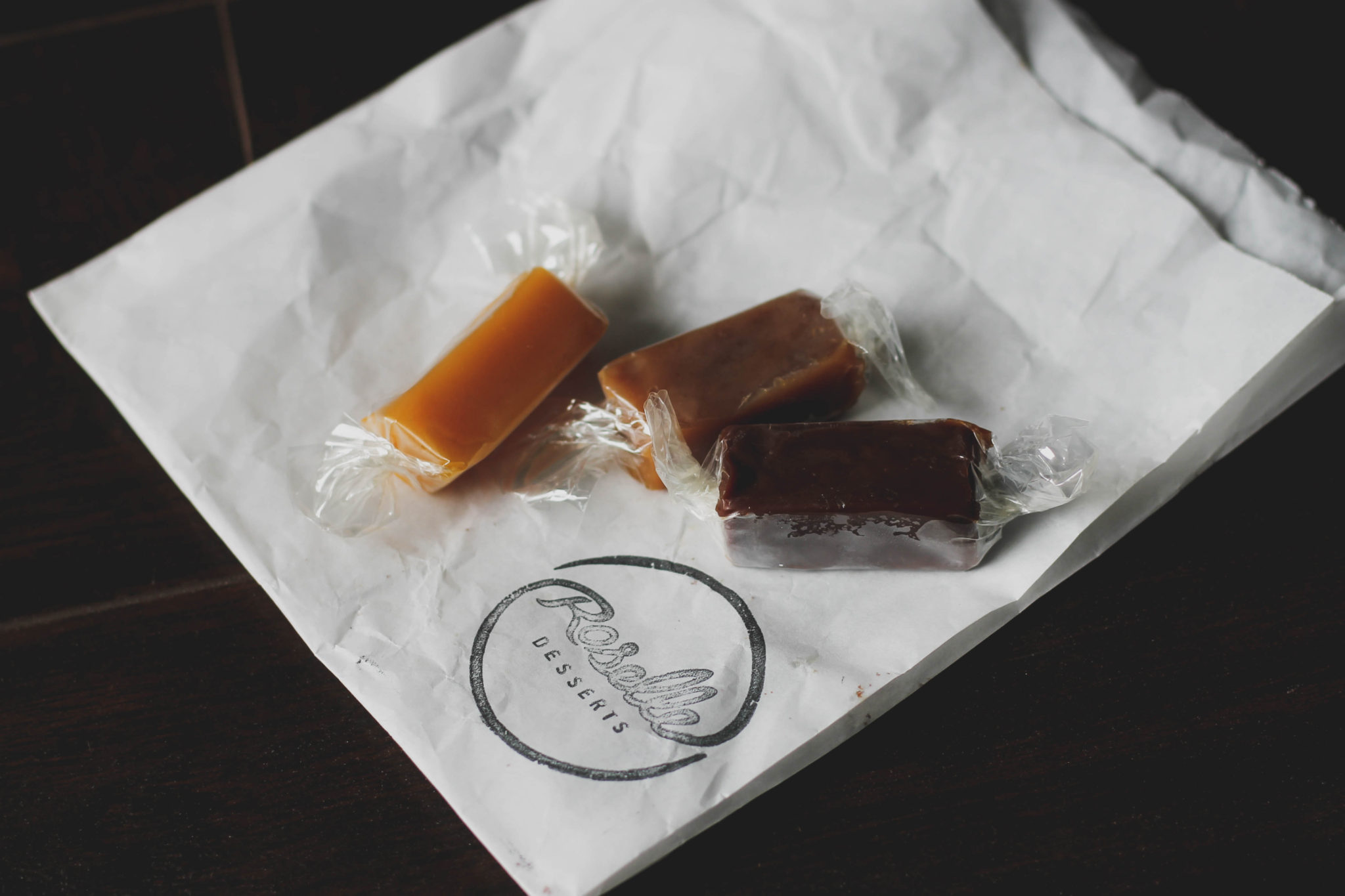 Three caramels in three flavours sitting on a white paper bag from Roselles bakery
