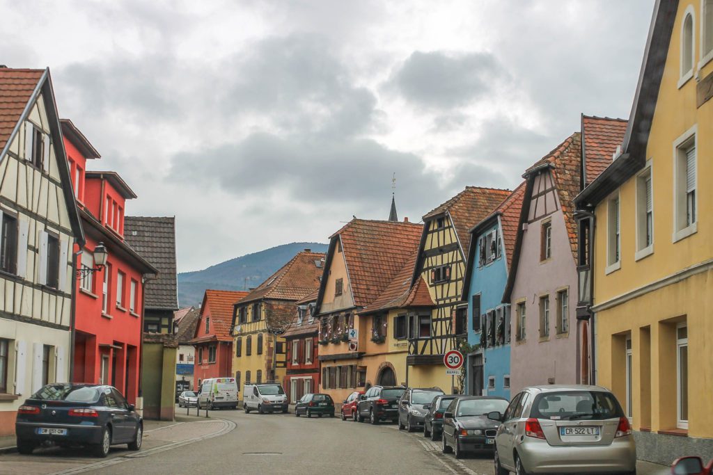Half timbered houses in multiple shades of pastel in Alsace region of France
