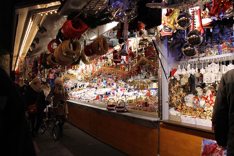 Christmas market stall at Strasbourg Christmas Market in France. Many wares are on sale including Christmas decorations