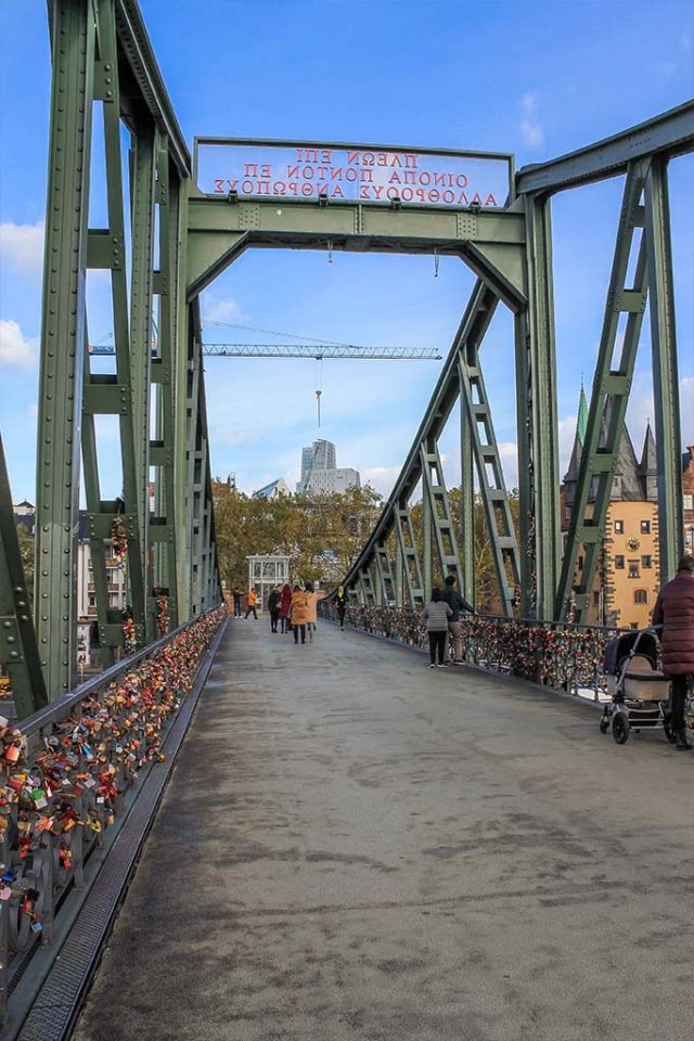 Eisener Steg green steel bridge showing locks on it and Greek inscription Frankfurt am Main, Germany