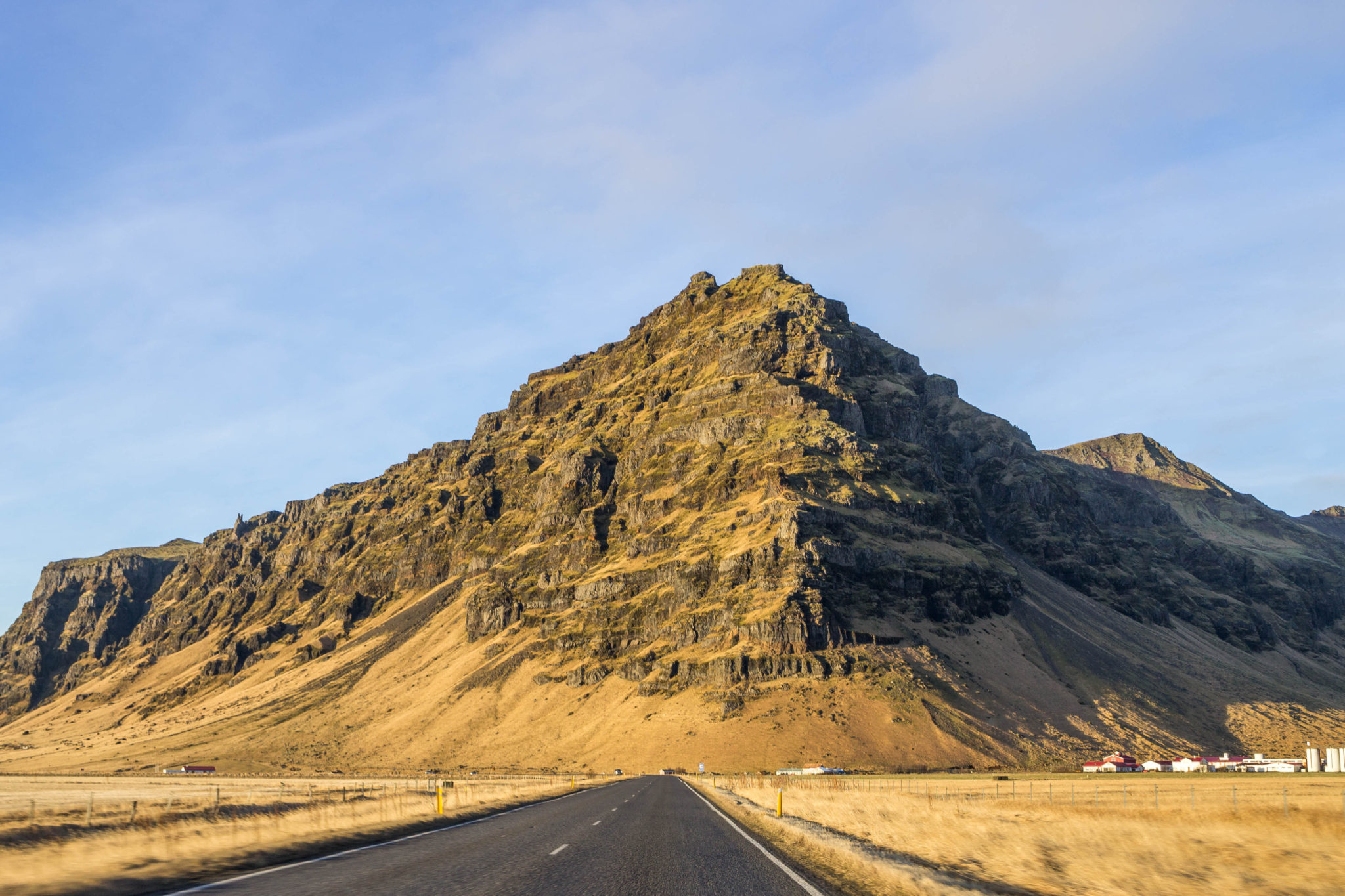 Black road in Iceland with a mountain in front of it