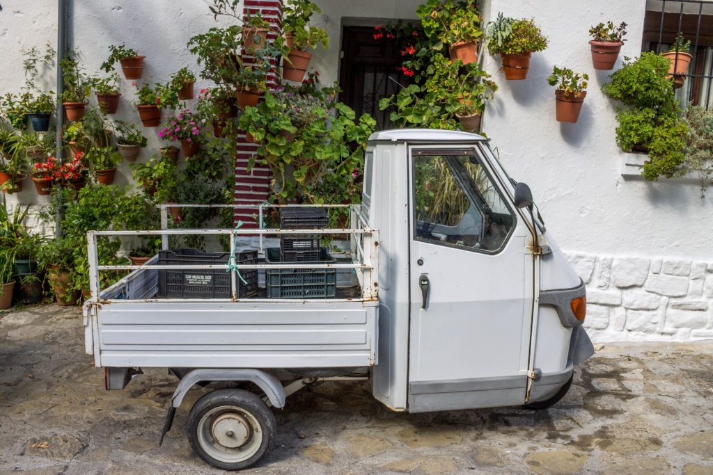 Geranium walls and a small truck in Grazalema, Spain