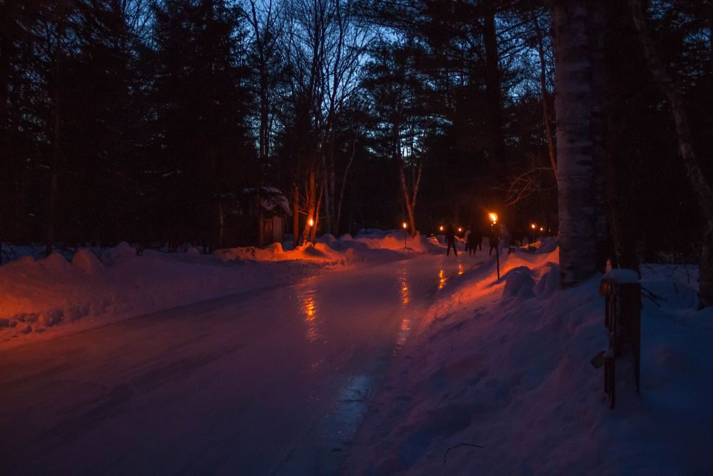 Arrowhead Provincial Park Fire and Ice skate night where tiki-torches light up a skating trail through the forest. Arrowhead is a fantastic winter day trip option from Toronto.
