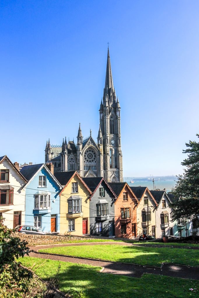 Cobh's deck of cards, a colorful line of houses on a steep road with St.Colman's Cathedral in the background
