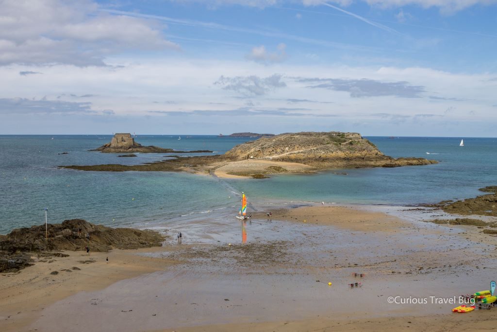Views of the beach at Saint Malo in Brittany, France. At high tide all access is cut off as the water goes up to the walls of the city. Saint Malo was made famous in the novel All the Light You Cannot See and is a great stop on your France Road Trip itinerary