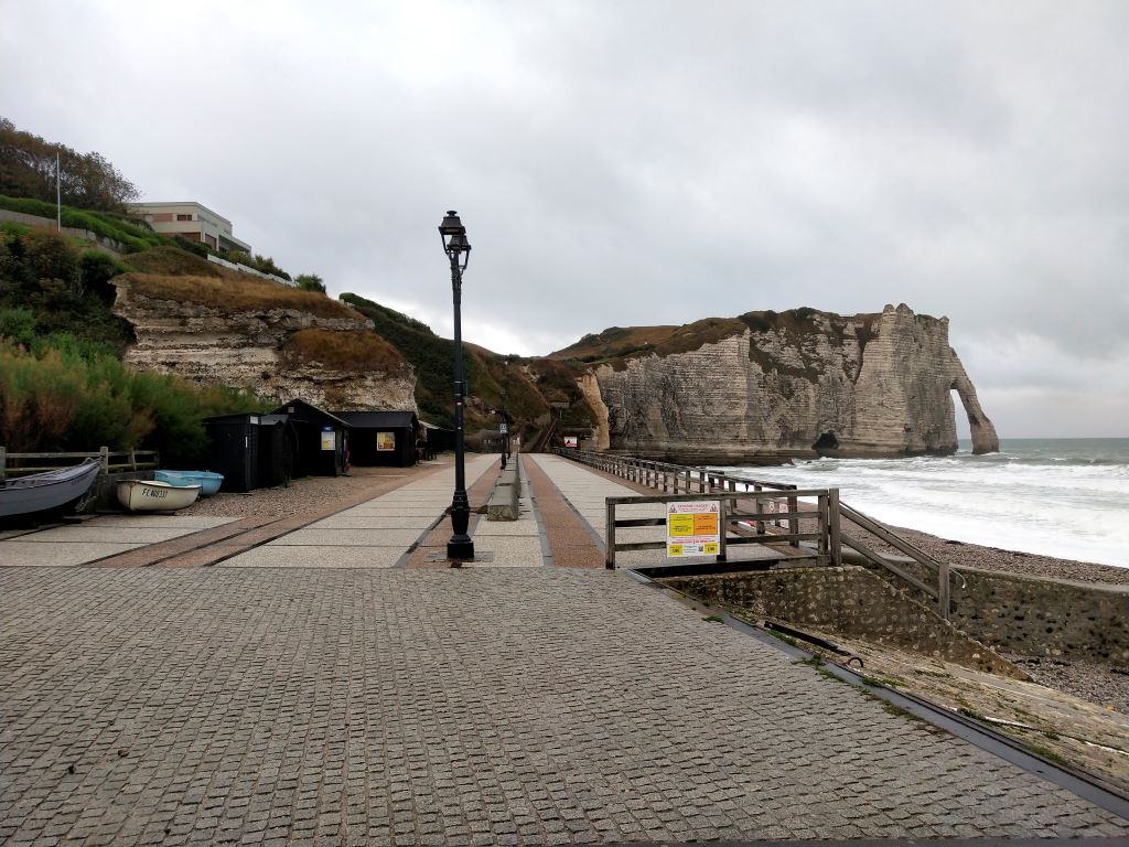 The town of Etretat in France with beautiful white cliffs. The cliffs are the highlight of a visit and have WWII significance as well as being an inspiration for painters like Monet. 