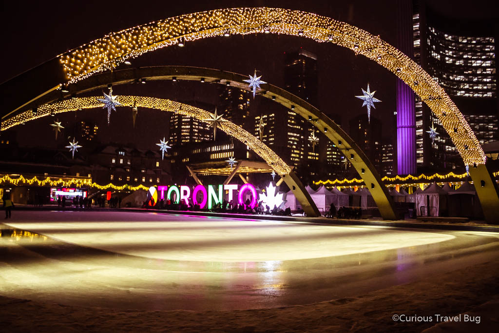 Nathan Phillips Square in Toronto lit up by Christmas lights and the Toronto sign. This is one of the top winter activities in the city.