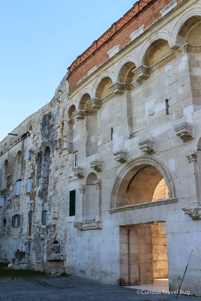 The Golden Gate of Diocletian's Palace in Split, Croatia. The walls of this Roman Palace are one of the top things to do in Split when you visit. It still is in use as a modern city and people live within this palace.