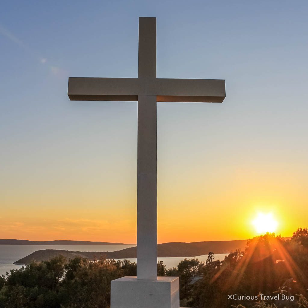 The large cross on Marjan Hill at sunset with the Adriatic Sea in the background. This is one of the best activities in Split, Croatia.