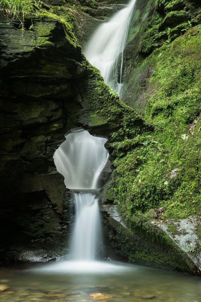 St Nectans Glen is one of the best waterfalls in the UK and is really close to Merlin's Cave of the King Arthur legends. This is waterfall is an easy hike that rewards you with this scenic waterfall.