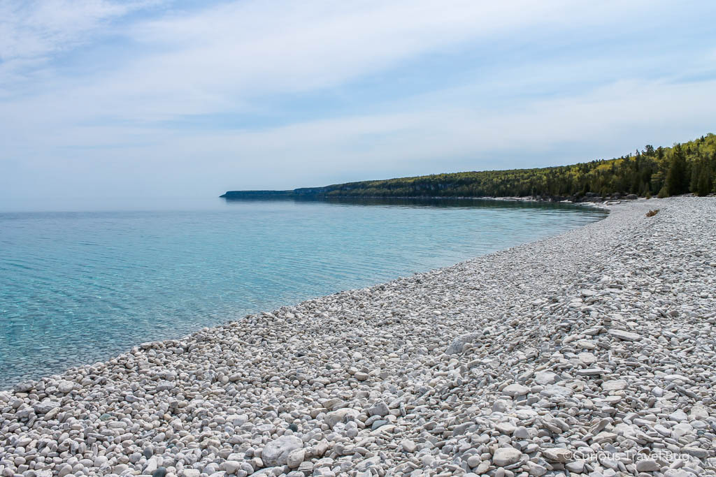 White stone beach with crystal clear water on the shore of Georgian Bay in Southern Ontario. Halfway Log Dump beach in Bruce Peninsula National Park