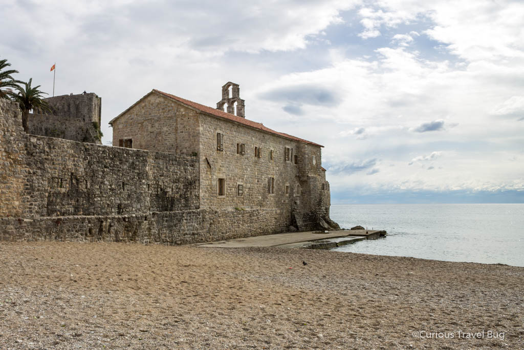 Views of Budva Old Town Beach and Santa Marija of Punta Church in Montenegro this beach is adjacent to the historic walled old town of Budva and is worth a visit if you are in Montenegro for the day from Dubrovnik.