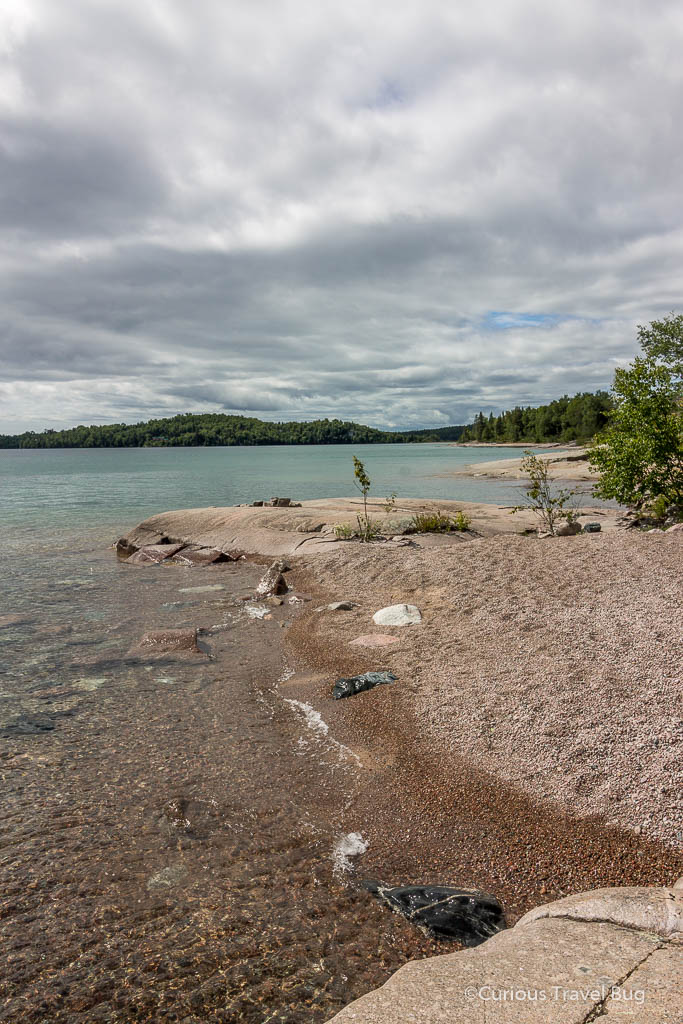 Beach at Rossport with crystal clear water of Lake Superior and red rock beach.Rossport is a gorgeous location to stop at when doing a road trip in Northern Ontario.
