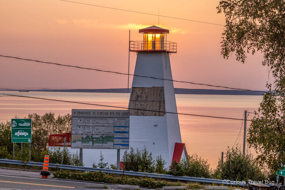 Sunrise with the sun behind a lighthouse in St. Simeon, Quebec. This a great place to explore the Saguenay Fjord and Tadoussac so its the perfect stop on your first night of your road trip to Quebec