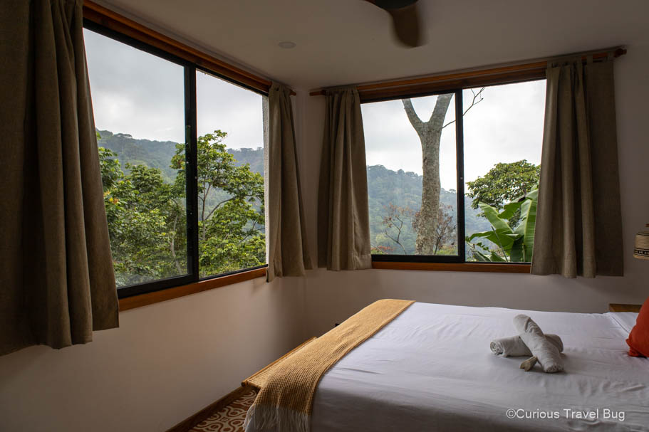 Hotel room at Masaya Casas viejas hostel in Minca, Colombia with windows offering views out to the mountains and wildlife