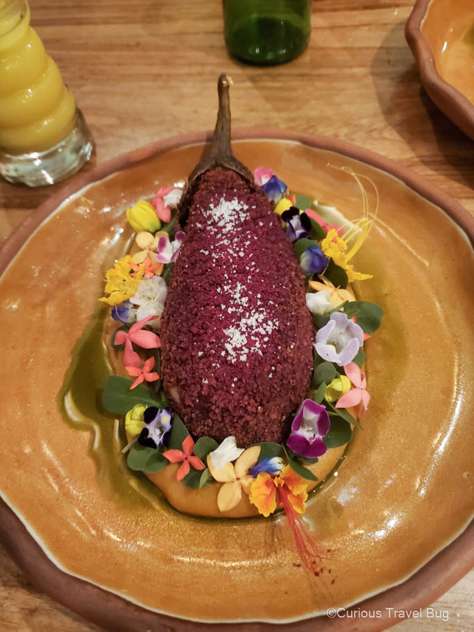 A vegetarian main course at Celele in the shape of an eggplant with fresh flowers surrounding it