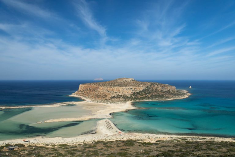View of Balos Bay in Crete with clear water and a white sand beach. This one week itinerary for Crete is the perfect Crete road trip