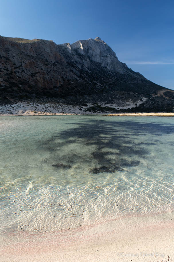 The clear water at Balos Bay with some pink sand