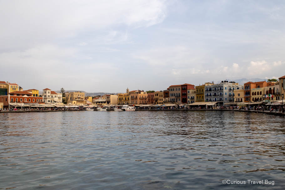 View of Chania's historic harbor with colorful Venetian-style architecture. A visit to Chania is a must on a first time road trip to Crete.