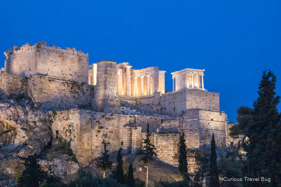 View of the Acropolis lit up at night from Areopagus Hill. This is an excellent place to watch the sunset in Athens while visiting.
