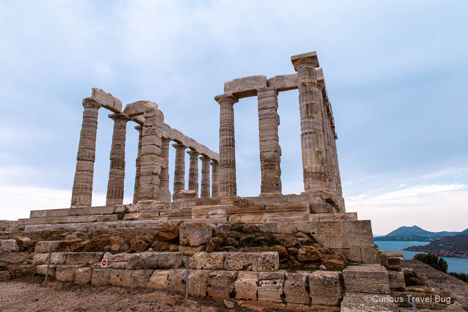 The Temple of Poseidon on an overcast day with the sea behind it. This Temple to the God of the Sea is found near Sounion, Greece and is a popular destination when visiting Athens for four days.
