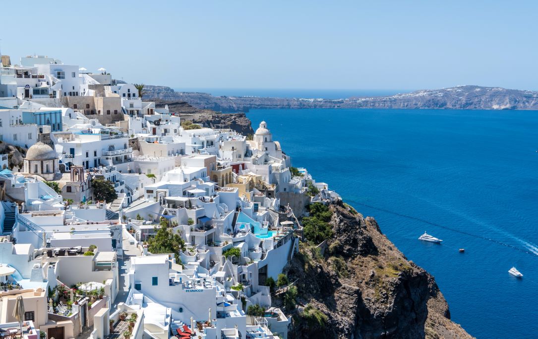 View of Santorini, Greece with white buildings and the Aegean Sea and Caldera. You can visit Santorini on a day trip from Athens.